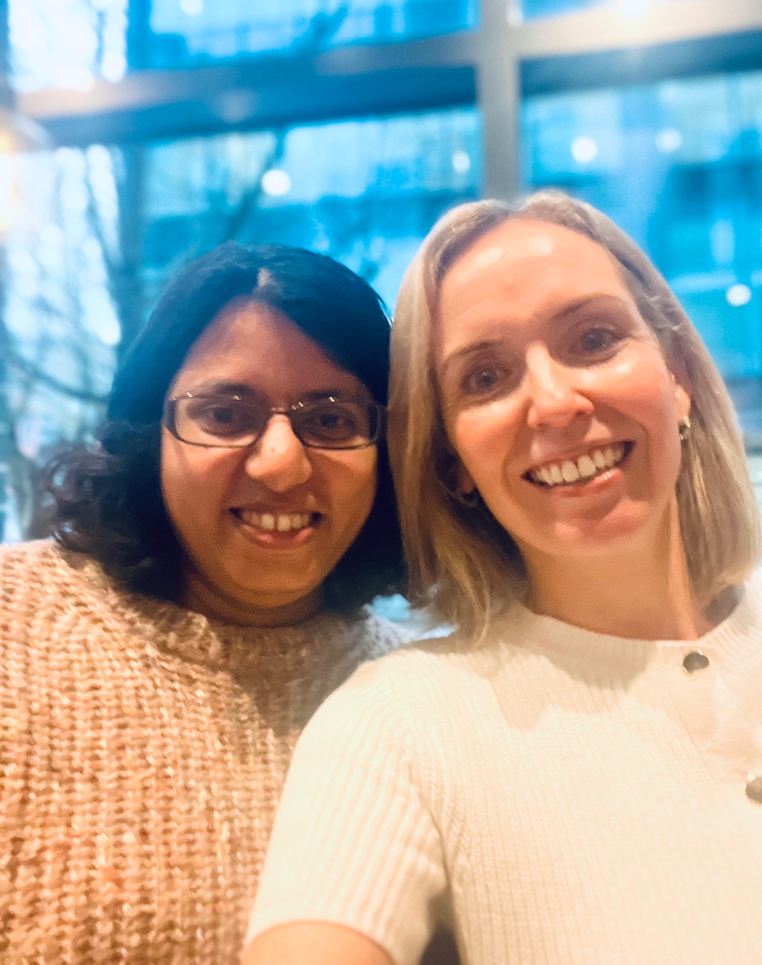 Leah with a legal community friend smiling together at an indoor networking event
